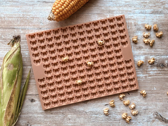 Backmatte 'Arsch mit Ohren' mit gebackenen Hundekeksen und Maiskolben auf Holz
