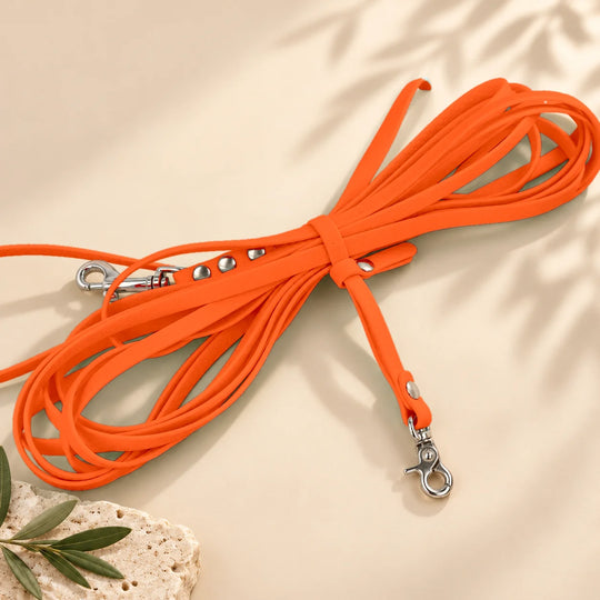 Hexa Schleppleine Neonorange, aufgerollt mit Schleppleinenhalter auf hellem Sand – Exceptional