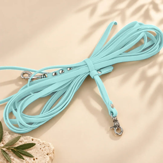 Hexa Schleppleine Pastellblau, aufgerollt mit Schleppleinenhalter auf hellem Sand – Exceptional