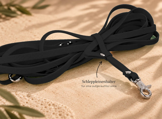 Hexa Schleppleine Schwarz, aufgerollt mit Schleppleinenhalter auf Sand – Exceptional